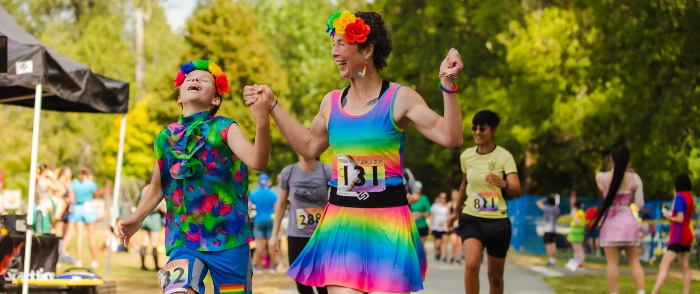 Parent and child crossing the finish line in fun costumes.